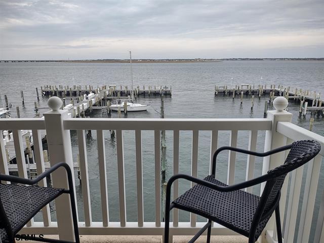 balcony featuring a water view and a dock