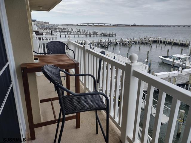 balcony with a water view and a dock