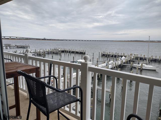 balcony featuring a water view and a dock