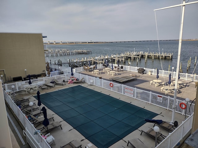 view of pool with a water view and a dock