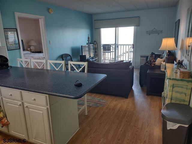 kitchen with white cabinets, a center island, a breakfast bar area, and light hardwood / wood-style flooring