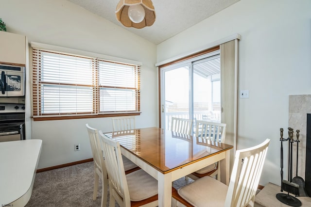 dining space featuring lofted ceiling and carpet