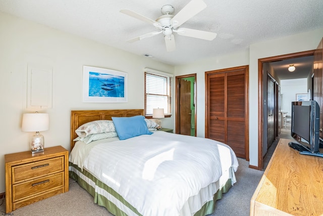 carpeted bedroom featuring a textured ceiling and ceiling fan