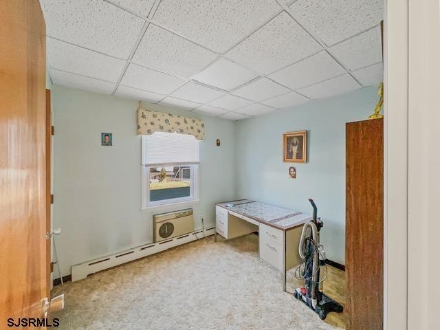 miscellaneous room with a drop ceiling, light colored carpet, and baseboard heating