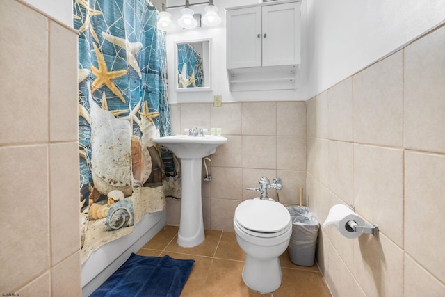 bathroom featuring tile patterned flooring, tile walls, shower / bath combo with shower curtain, and toilet