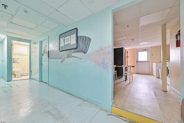 hall featuring a drop ceiling and washer / clothes dryer