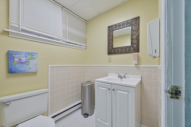 bathroom featuring a baseboard radiator, vanity, tile patterned floors, and tile walls