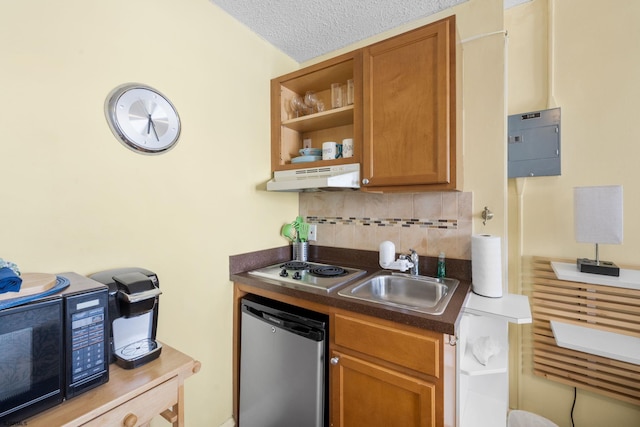 kitchen featuring stovetop, sink, a textured ceiling, dishwasher, and decorative backsplash