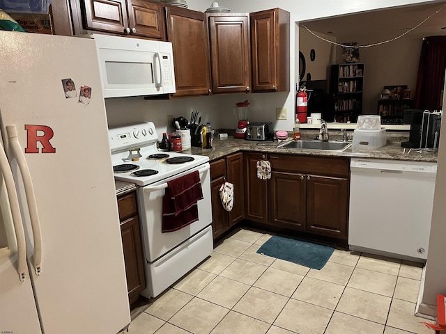 kitchen featuring light tile patterned flooring, dark brown cabinets, sink, and white appliances