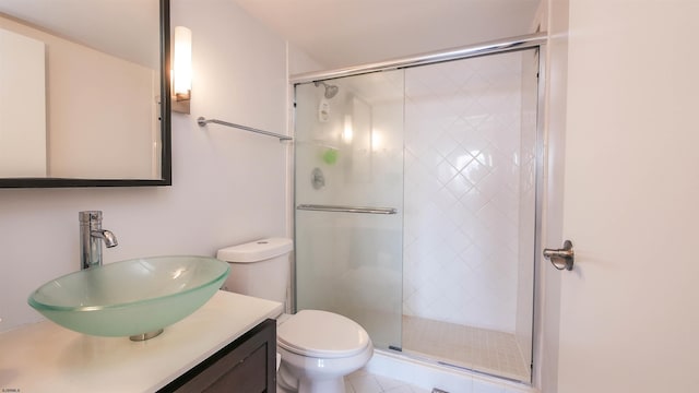 bathroom featuring vanity, toilet, and a shower with shower door