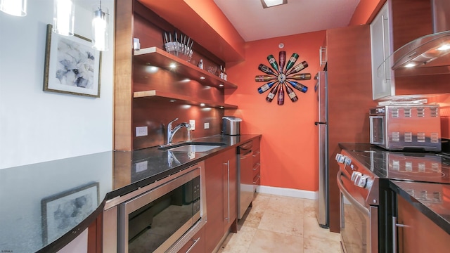 kitchen featuring ventilation hood, appliances with stainless steel finishes, sink, and dark stone counters