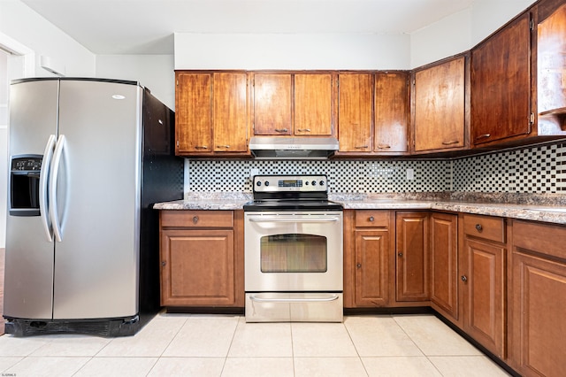 kitchen with light tile patterned flooring, appliances with stainless steel finishes, and light stone counters