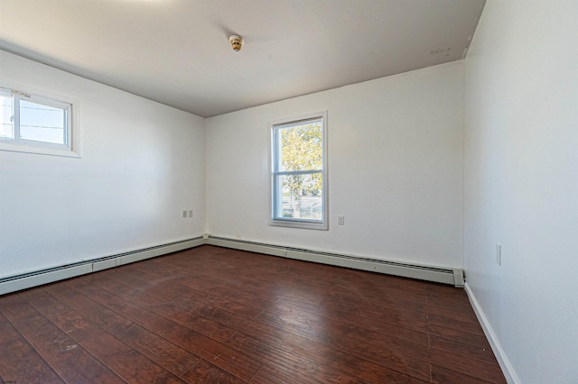 spare room with dark hardwood / wood-style floors and baseboard heating