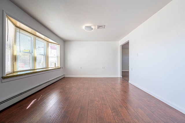 unfurnished room featuring wood-type flooring and a baseboard heating unit