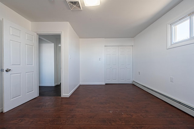 interior space featuring a baseboard heating unit, dark hardwood / wood-style floors, and a closet