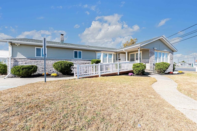 ranch-style home featuring a front lawn and covered porch