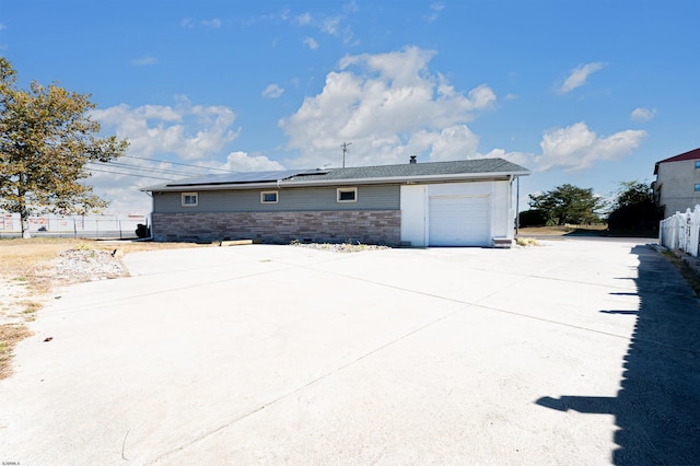 view of property exterior with a garage and solar panels