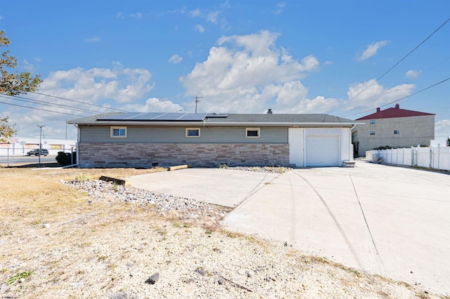 exterior space featuring a garage and solar panels