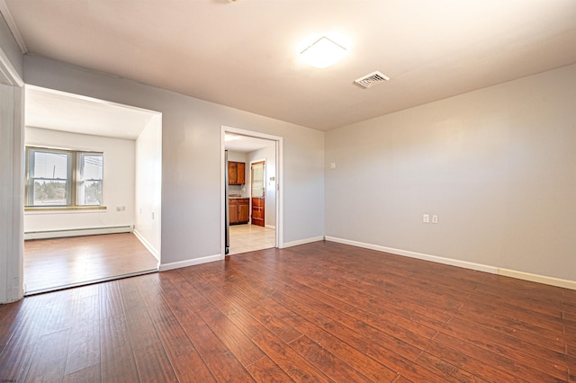 spare room with light hardwood / wood-style flooring and a baseboard heating unit