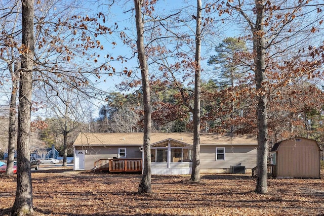 view of front facade with a wooden deck, central AC unit, and a sunroom