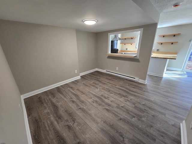 spare room featuring a baseboard radiator and dark hardwood / wood-style floors