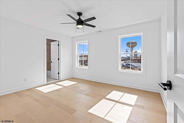 empty room with ceiling fan and light hardwood / wood-style floors