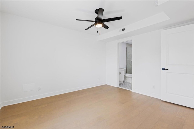 unfurnished bedroom featuring ensuite bathroom, ceiling fan, and light hardwood / wood-style flooring