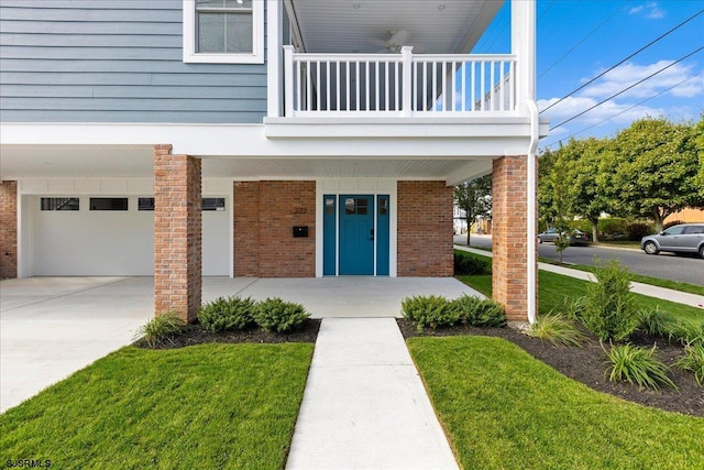 view of exterior entry featuring a balcony, a garage, and a lawn