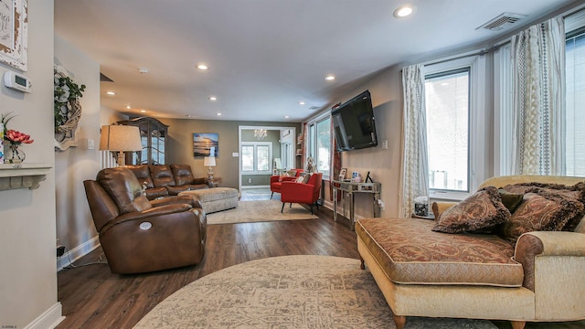 living room with plenty of natural light and dark hardwood / wood-style flooring