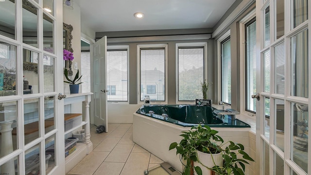 bathroom featuring tiled bath, tile patterned floors, and french doors