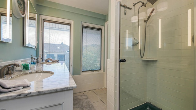 bathroom with tiled shower, tile patterned floors, and vanity