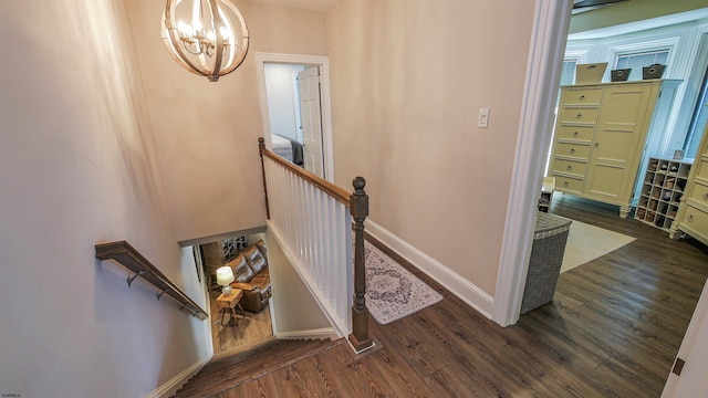 stairs with an inviting chandelier and wood-type flooring