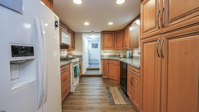 kitchen featuring white appliances, dark hardwood / wood-style flooring, and sink