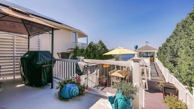 wooden deck with a gazebo and a grill