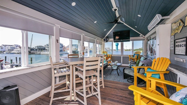 sunroom with ceiling fan, a water view, lofted ceiling, and wood ceiling