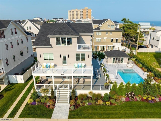 back of house with a fenced in pool, a patio, a balcony, and an outdoor structure