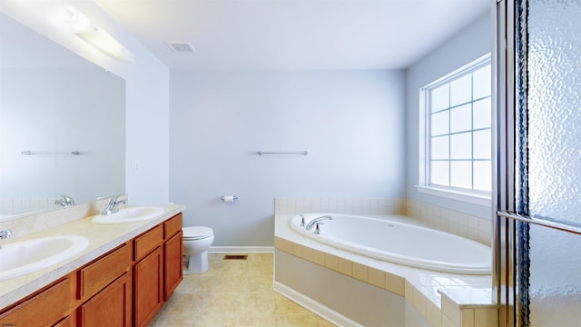 bathroom featuring vanity, tiled bath, and toilet