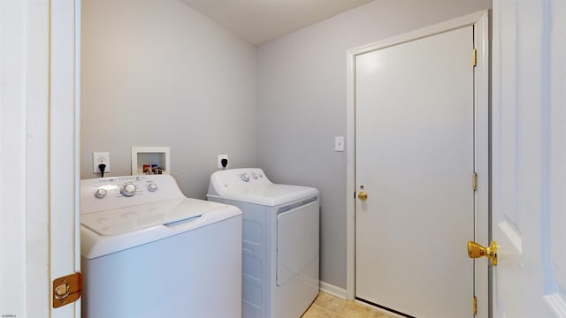 clothes washing area with washer and dryer and light tile patterned floors