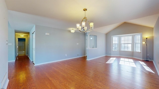 unfurnished room with hardwood / wood-style flooring, lofted ceiling, and a chandelier