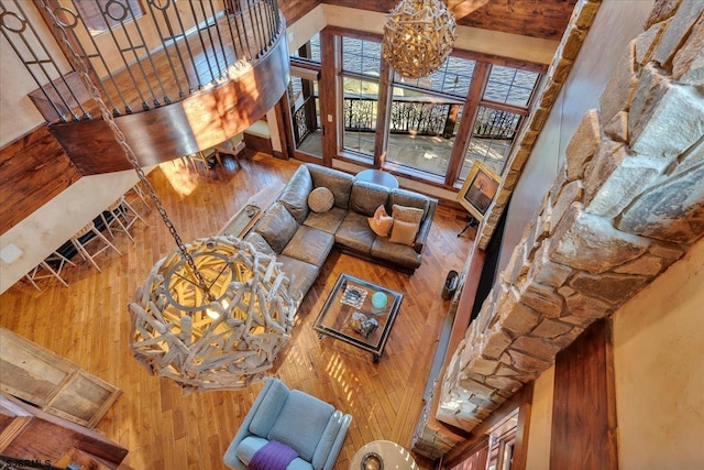 living room with a towering ceiling, wood-type flooring, and a notable chandelier