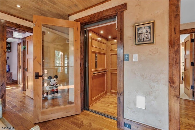 interior space featuring crown molding, wooden ceiling, and light hardwood / wood-style floors