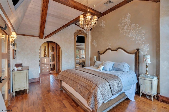 bedroom with beamed ceiling, wood-type flooring, an inviting chandelier, and high vaulted ceiling