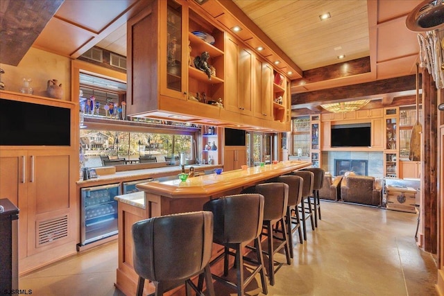 bar featuring beverage cooler, a tile fireplace, and wooden ceiling