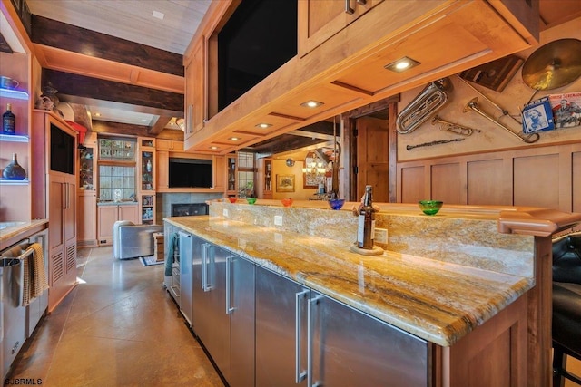 kitchen with pendant lighting, a breakfast bar area, light stone countertops, beam ceiling, and a spacious island