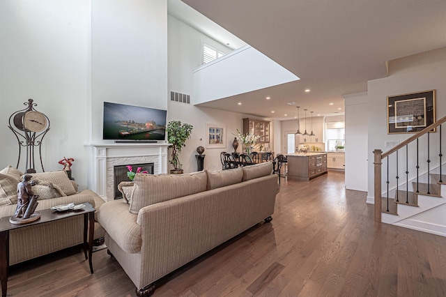 living room with dark wood-type flooring and a fireplace