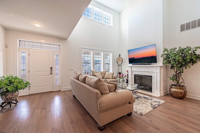 living room with hardwood / wood-style flooring and a towering ceiling