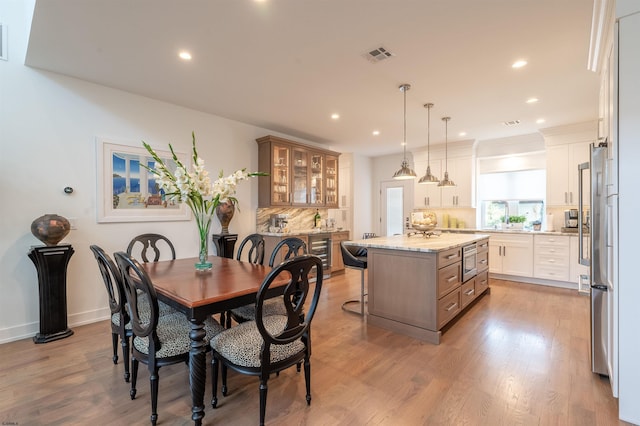 dining area featuring wine cooler and light hardwood / wood-style floors