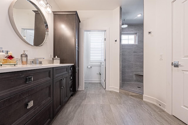 bathroom with vanity and tiled shower