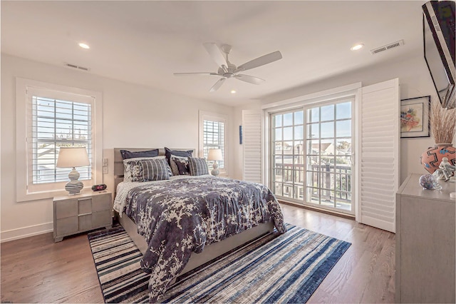 bedroom featuring ceiling fan, access to exterior, light hardwood / wood-style floors, and multiple windows