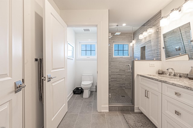 bathroom featuring vanity, toilet, tile patterned floors, and walk in shower